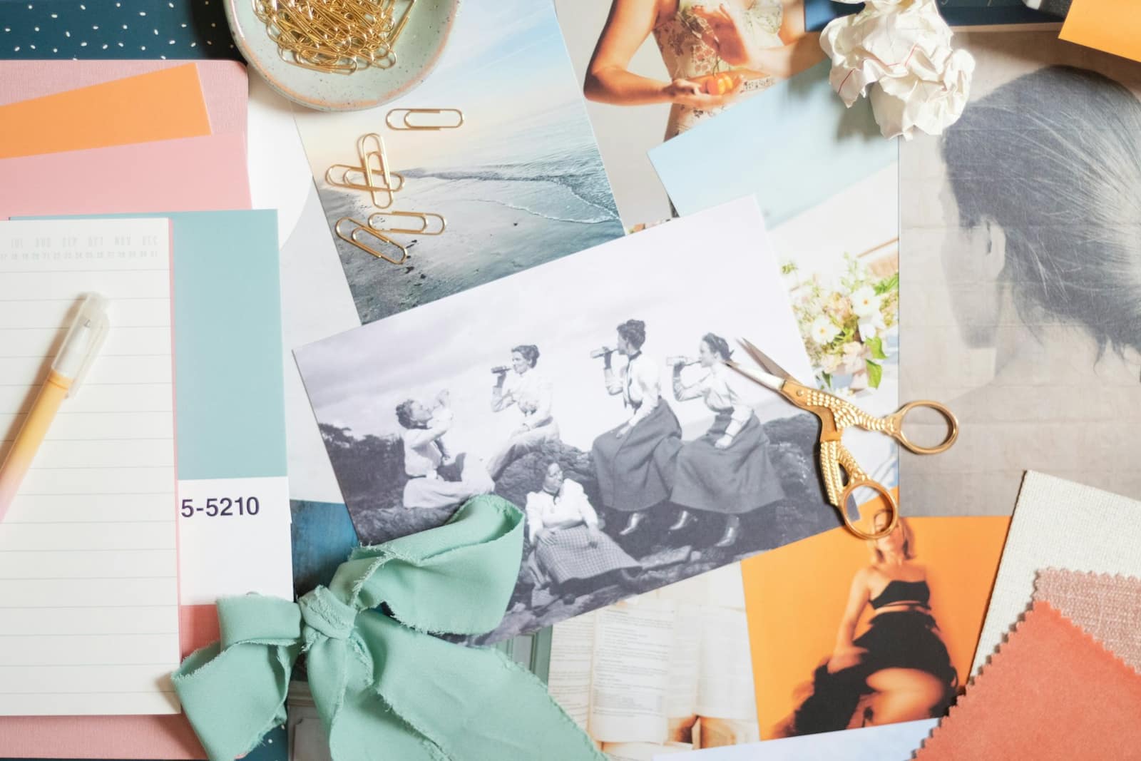 Images, papiers colorés et ciseaux dorés étalés sur une table